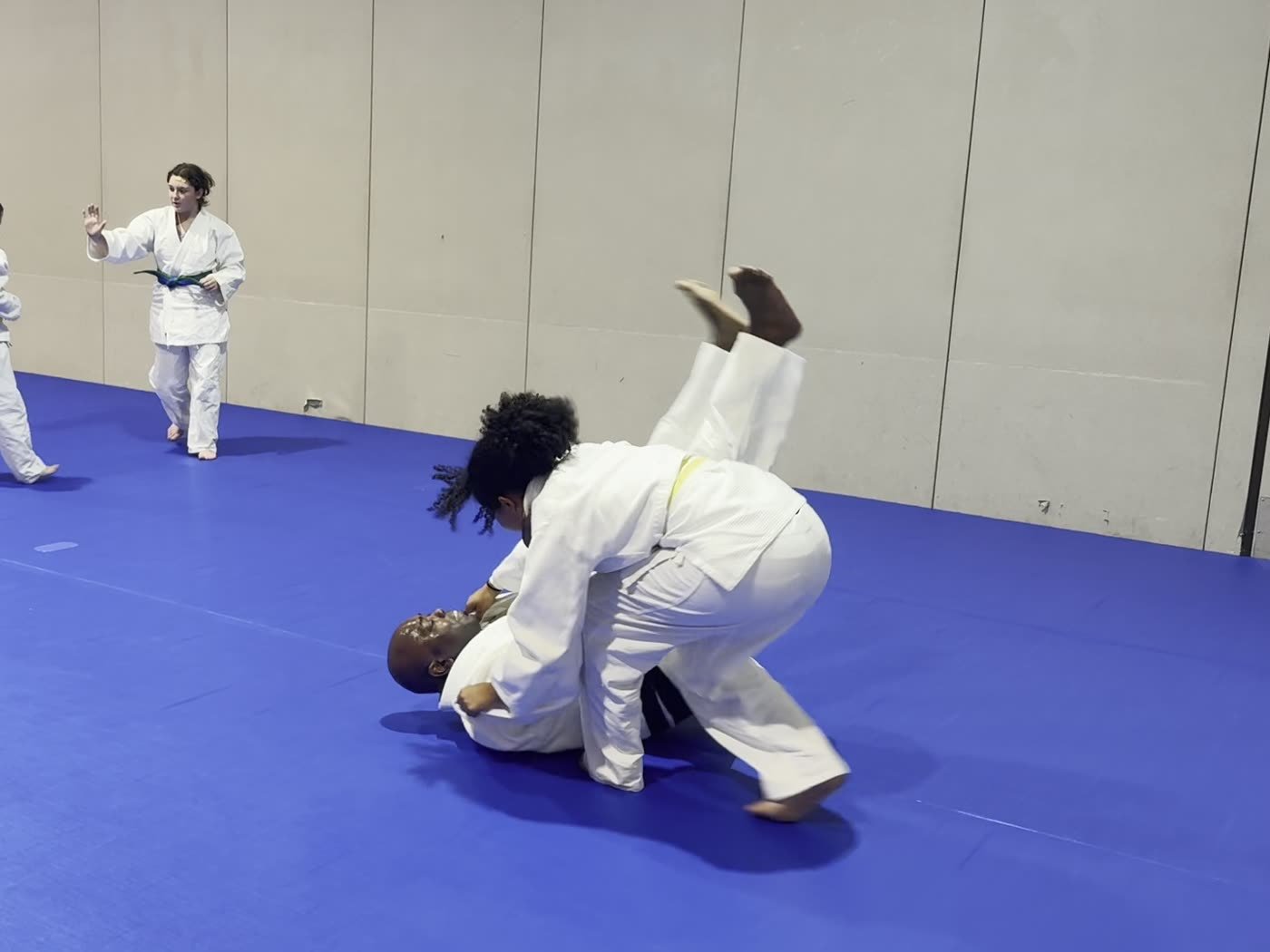 A student throws Coach Dennis during partner practice