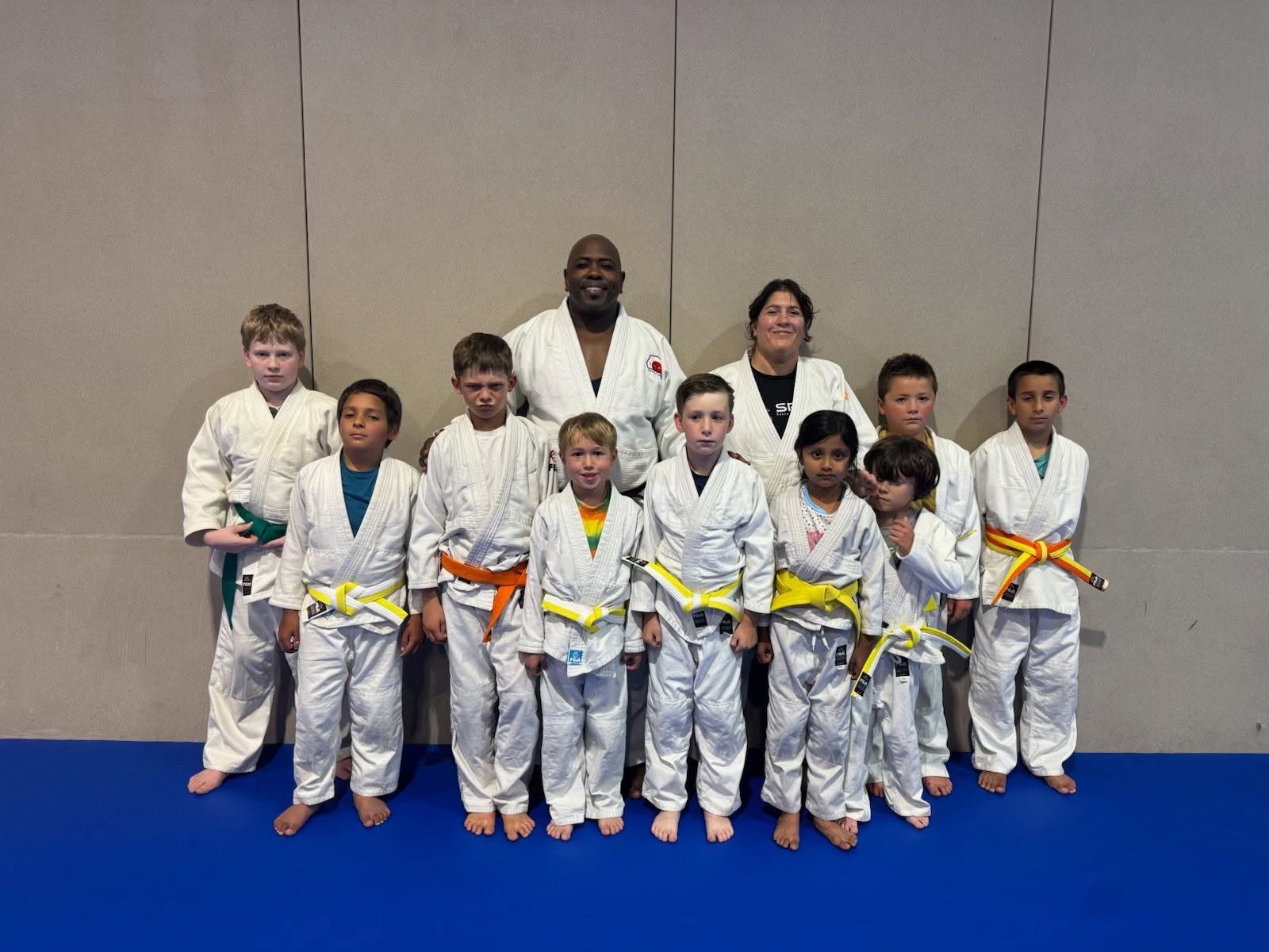 Shining Together Judo kids lined up in their judogi with coaches after class
